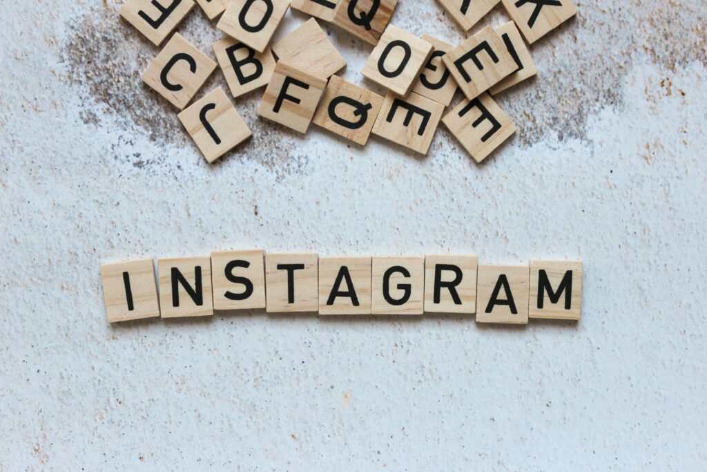 Wooden letter blocks arranged to spell 'Instagram' on a textured surface.